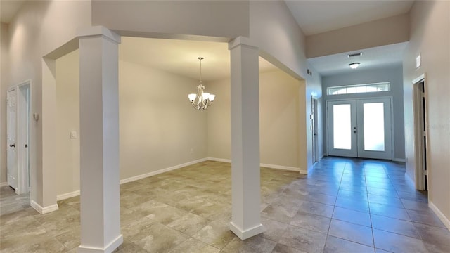 entrance foyer featuring an inviting chandelier and french doors