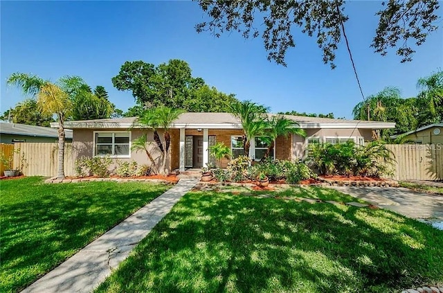 ranch-style home featuring a front lawn, fence, and stucco siding