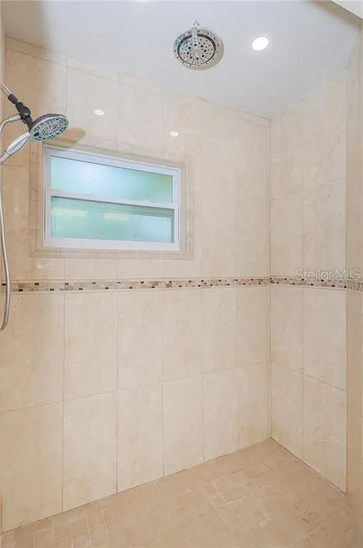 bathroom featuring tiled shower and a healthy amount of sunlight