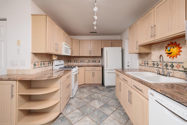 kitchen featuring white appliances, light stone counters, sink, and decorative backsplash