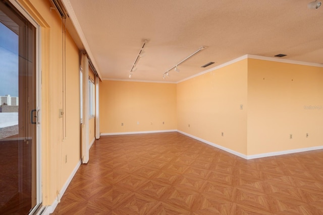 unfurnished room featuring track lighting, ornamental molding, parquet flooring, and a textured ceiling