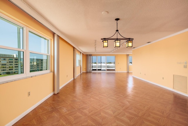 unfurnished room with a textured ceiling, crown molding, and light parquet flooring