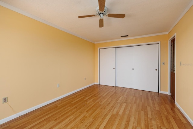 unfurnished bedroom featuring ceiling fan, ornamental molding, and light wood-type flooring