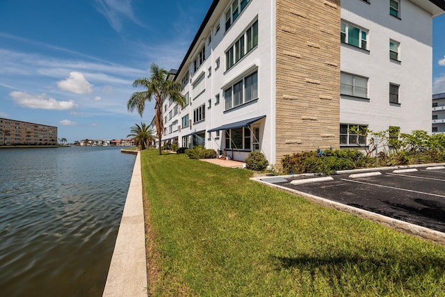 view of community featuring a water view and a lawn