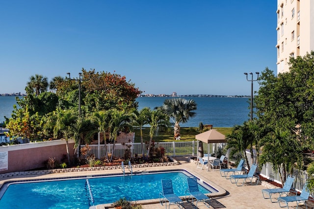 view of pool with a patio area and a water view