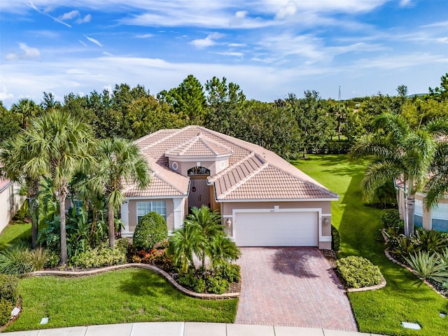 mediterranean / spanish-style house with a front yard and a garage