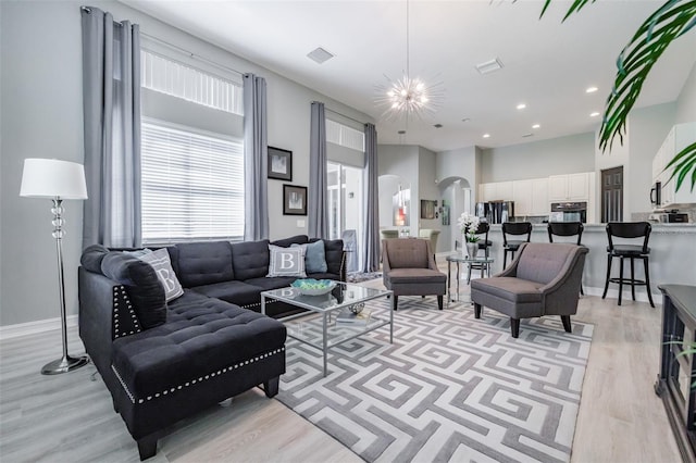 living room featuring an inviting chandelier and light wood-type flooring