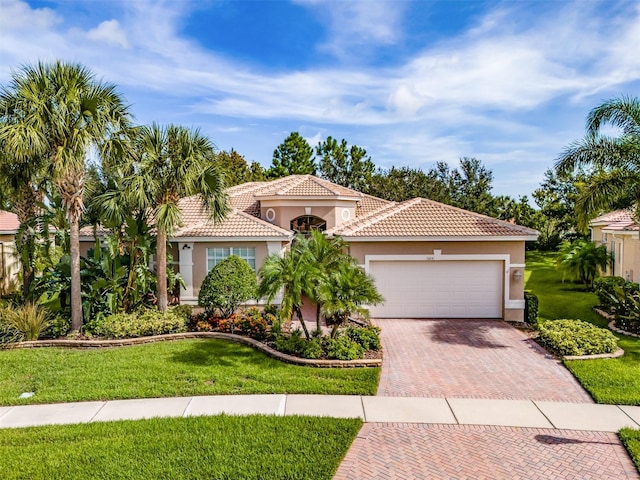 mediterranean / spanish-style house featuring a front yard and a garage