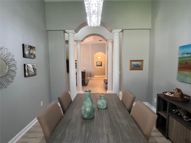 dining area with light hardwood / wood-style floors and a notable chandelier