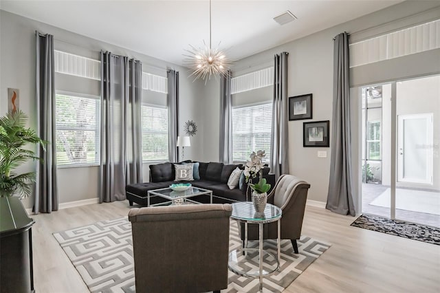 living room featuring a notable chandelier and light wood-type flooring