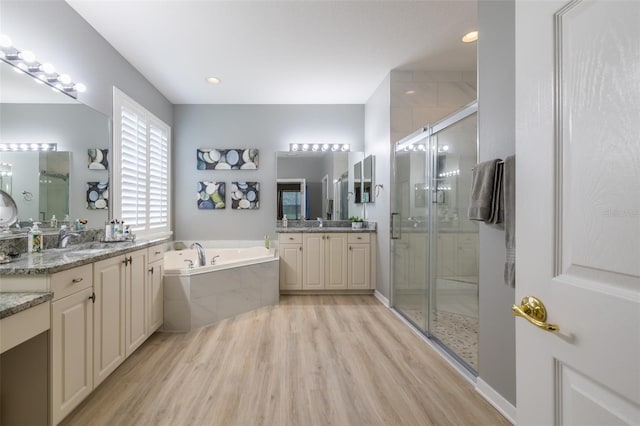 bathroom with vanity, hardwood / wood-style floors, and shower with separate bathtub