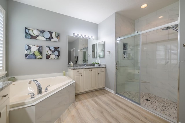 bathroom featuring vanity, hardwood / wood-style flooring, and independent shower and bath