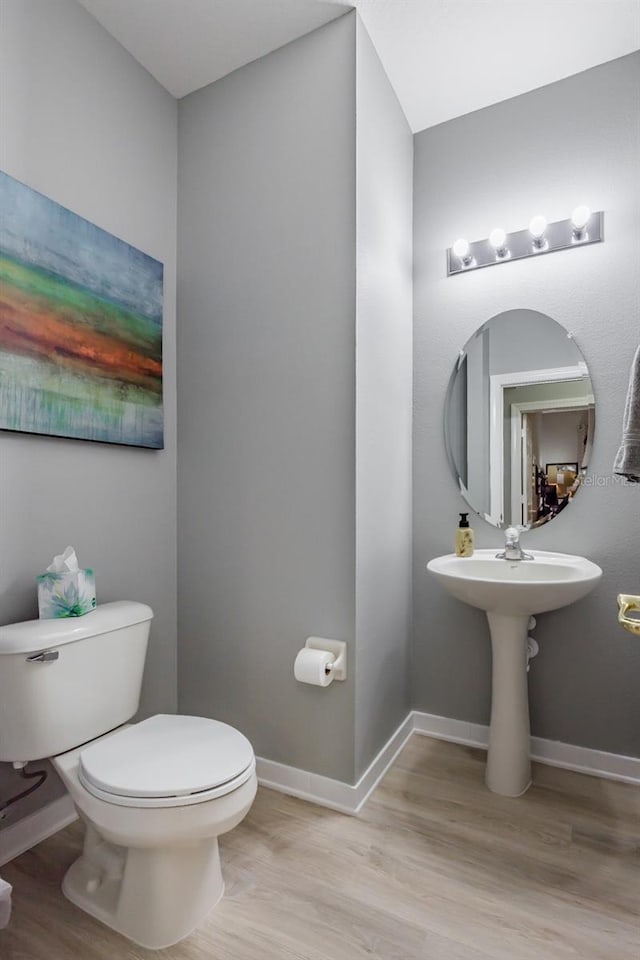 bathroom with toilet and hardwood / wood-style flooring