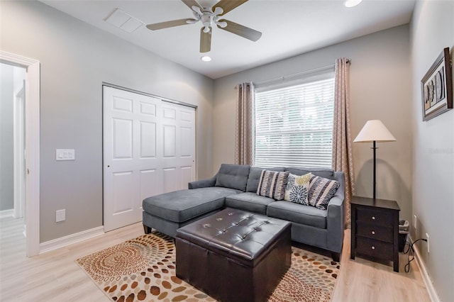 living room with light wood-type flooring and ceiling fan