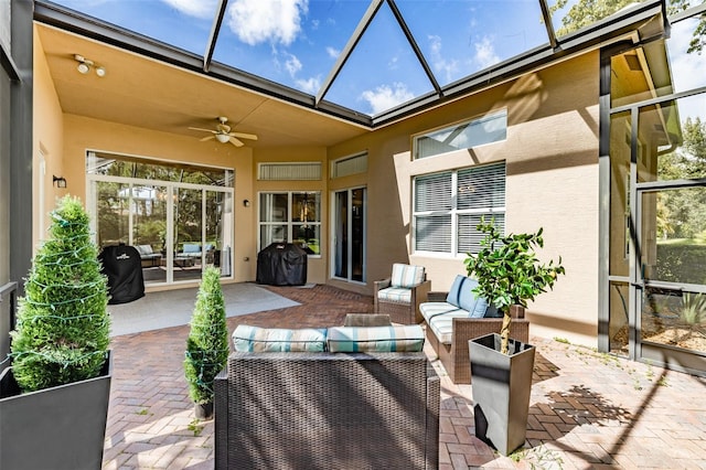 exterior space with ceiling fan, glass enclosure, and outdoor lounge area