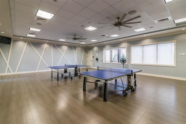 game room featuring a drop ceiling, hardwood / wood-style flooring, and ceiling fan