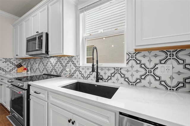 kitchen with backsplash, white cabinetry, ornamental molding, and appliances with stainless steel finishes