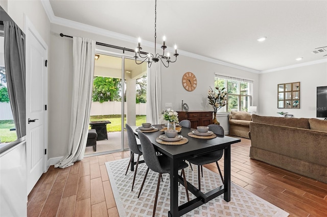 dining area featuring a notable chandelier, hardwood / wood-style flooring, and crown molding