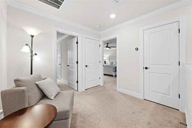 living area featuring crown molding, ceiling fan, and light colored carpet