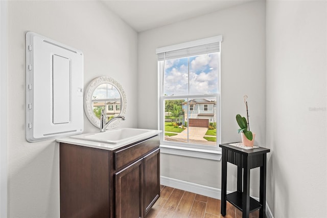 interior space featuring electric panel, light hardwood / wood-style floors, and sink