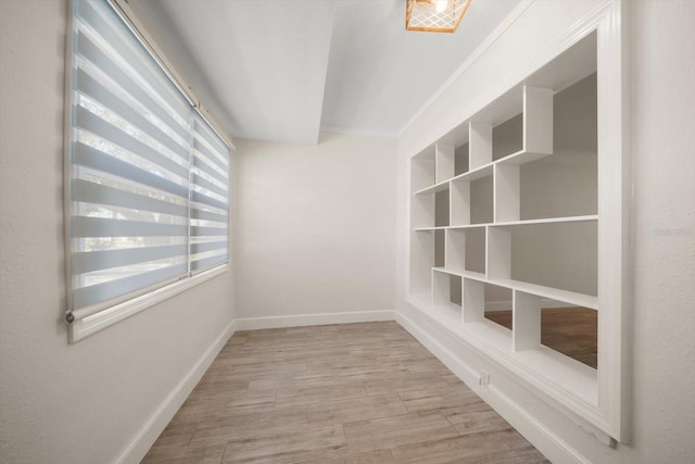 spare room featuring baseboards and wood finished floors