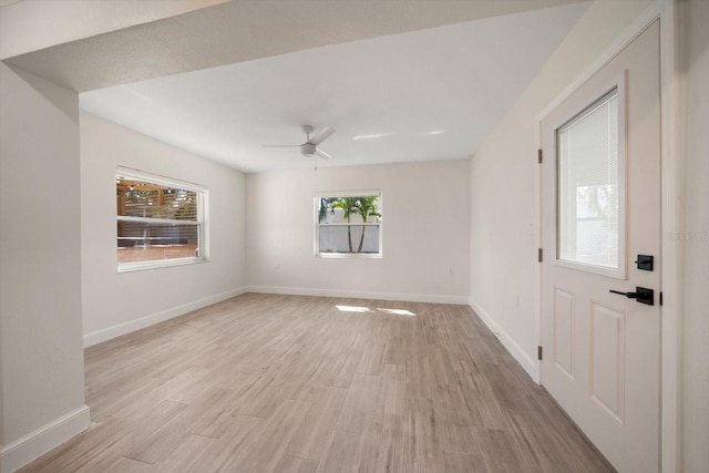 empty room featuring light wood-style flooring, baseboards, and a ceiling fan