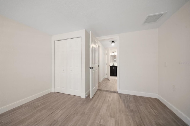 unfurnished room featuring visible vents, baseboards, and wood finished floors