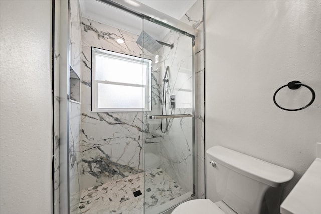 bathroom with a marble finish shower and toilet