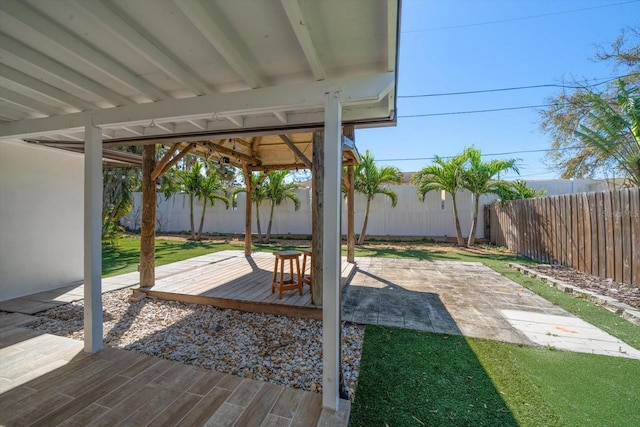 view of patio featuring a fenced backyard and a deck