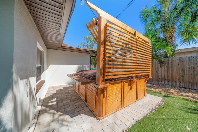 exterior space with a jacuzzi and fence