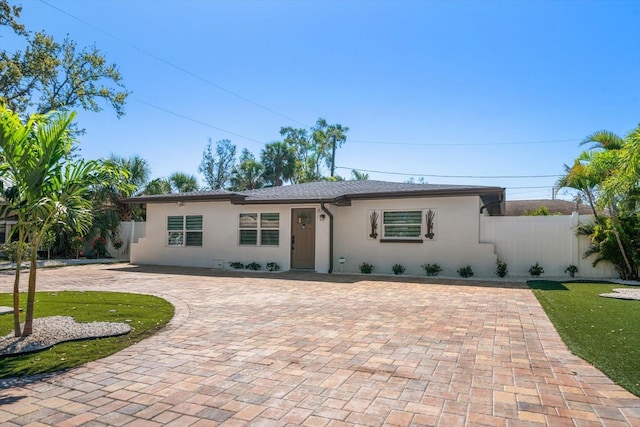 ranch-style home featuring fence and stucco siding