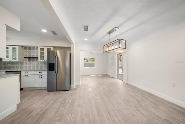 kitchen featuring light wood-type flooring, visible vents, decorative backsplash, and stainless steel fridge with ice dispenser