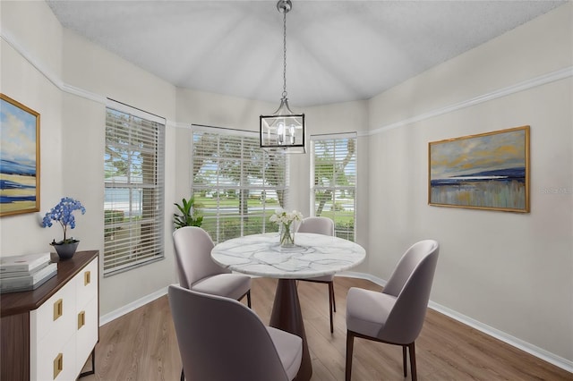 dining area with wood-type flooring and an inviting chandelier