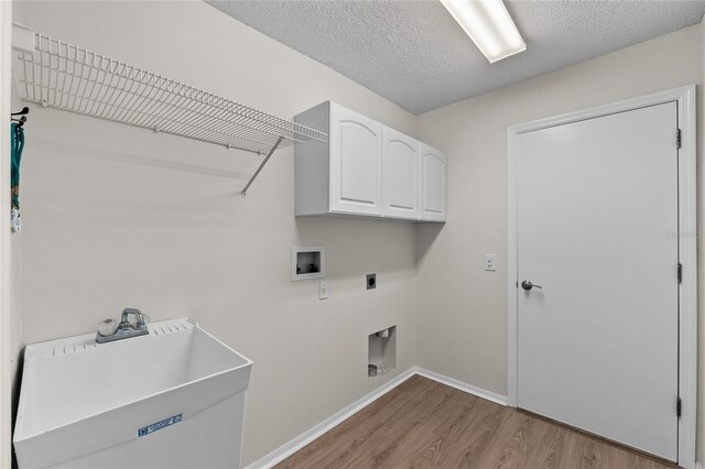 laundry area featuring hookup for a washing machine, hookup for an electric dryer, a sink, light wood-style floors, and cabinet space