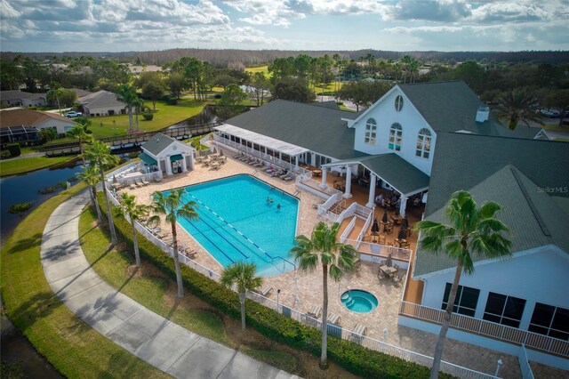 community pool with a patio area and fence