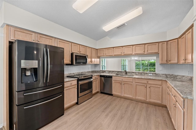 kitchen featuring stainless steel appliances, visible vents, light wood-style floors, light brown cabinets, and a sink