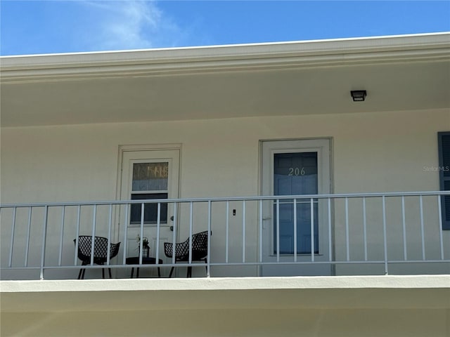 view of exterior entry with a balcony