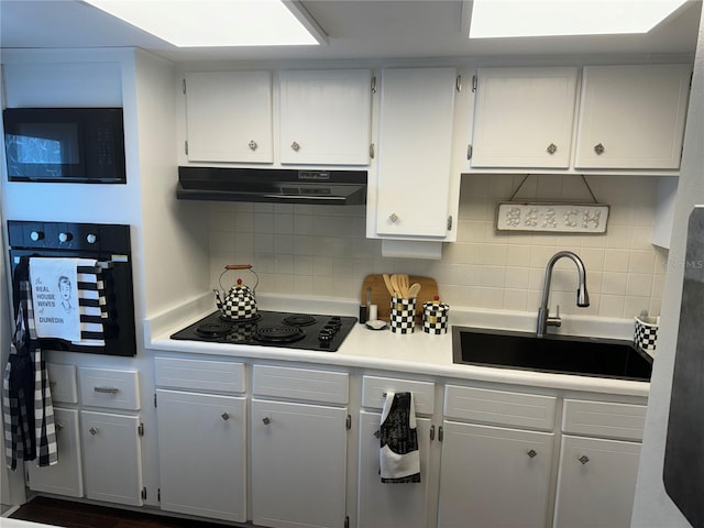 kitchen with white cabinets, sink, decorative backsplash, and black appliances