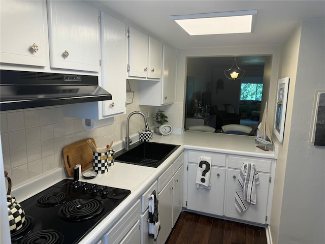 kitchen featuring sink, backsplash, dark wood-type flooring, white cabinetry, and black electric cooktop