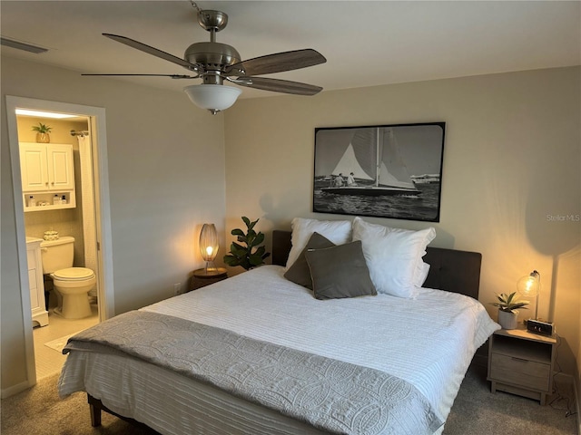 bedroom with ceiling fan, carpet floors, and ensuite bath