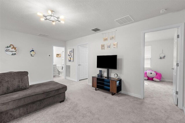 living room featuring light carpet, a notable chandelier, and a textured ceiling