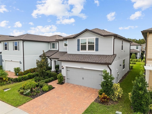 view of front of property featuring a front yard and a garage