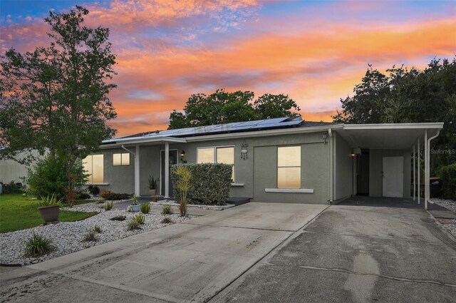 view of front of house featuring a carport and solar panels