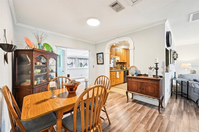 dining area featuring light hardwood / wood-style floors and crown molding