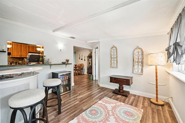 interior space featuring crown molding, decorative backsplash, beverage cooler, and wood-type flooring