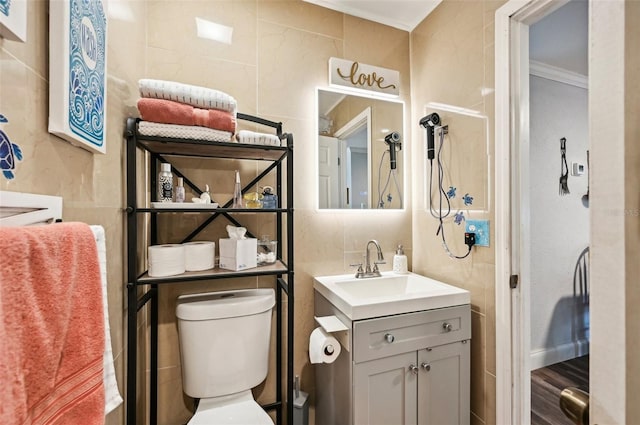 bathroom with vanity, hardwood / wood-style flooring, tile walls, and toilet