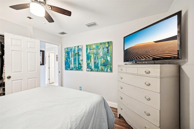 bedroom featuring a textured ceiling, dark wood-type flooring, and ceiling fan