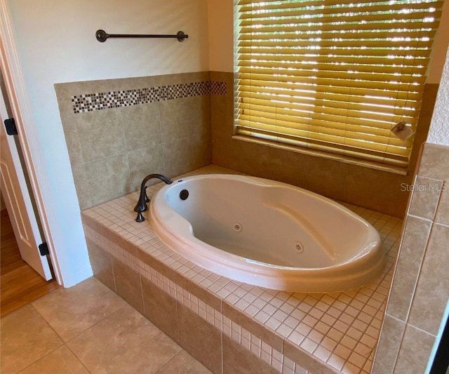 bathroom with tile patterned floors and tiled bath