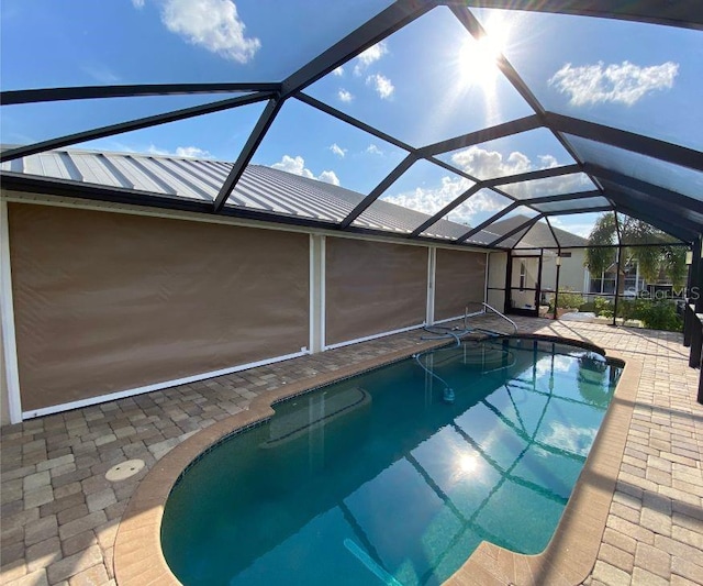 view of swimming pool with glass enclosure and a patio area