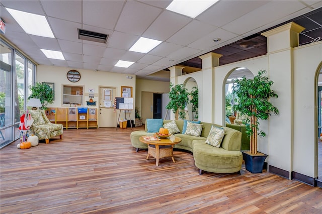 living room with light wood-type flooring and a drop ceiling